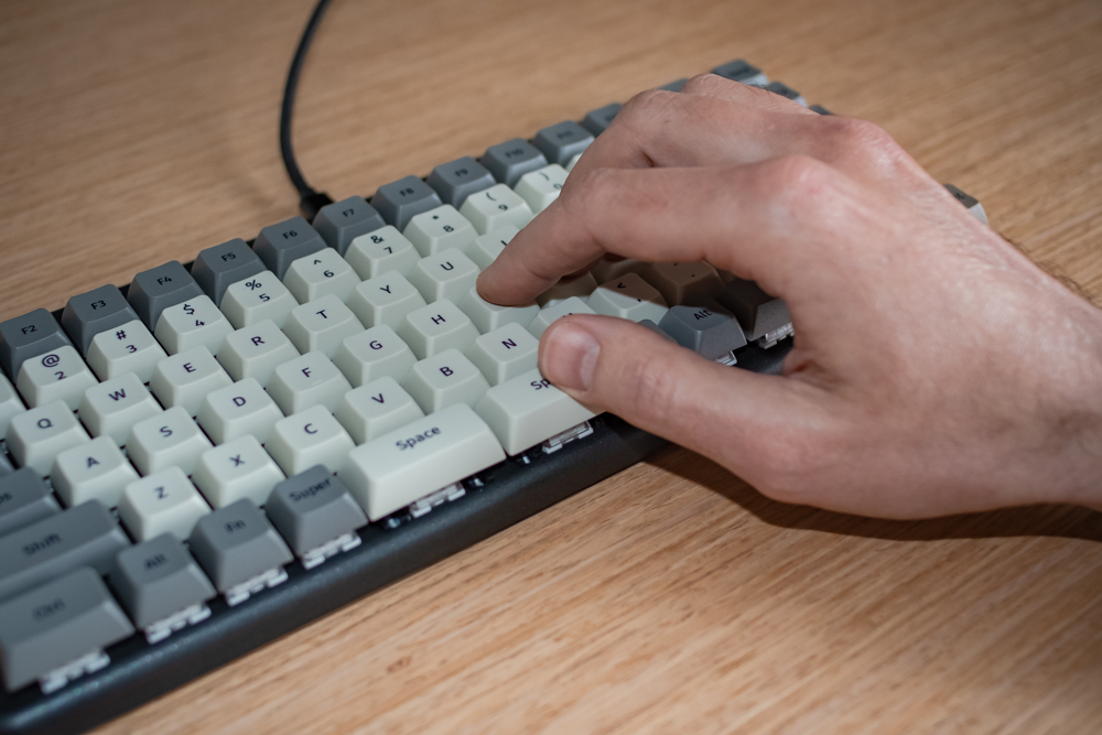 A person’s right hand resting on the keyboard, their thumb on the right Space bar, other fingers on the home row